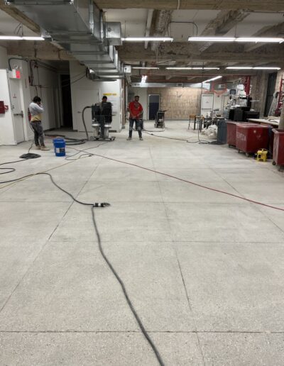 Workers polishing concrete floors in a commercial space